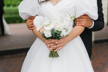 Bridal Bouquet In Groom Embrace