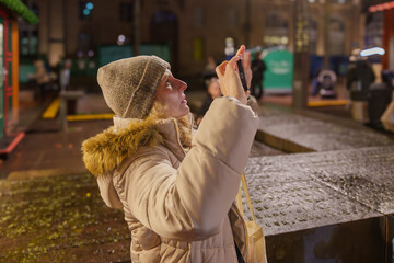 Woman taking a photo at a Christmas market.