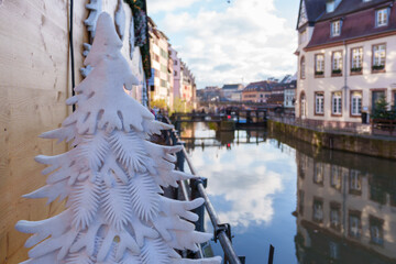 Snow-covered decorative tree near a canal in Strasbourg.