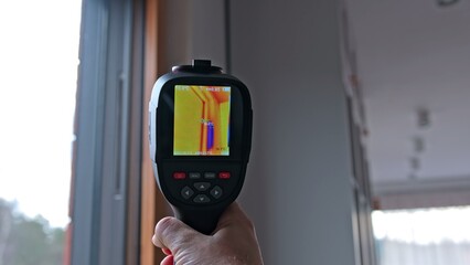 Contractor Engineer Performing Building Inspection for Cold Bridge Thremal Bypass in Window Frame using Thermal Vision Camera