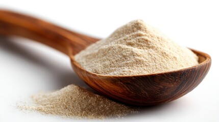 Wooden spoon with pile of beige powder on a white surface