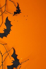 Halloween festive background design featuring bats,  and decorative branches. Top view, space for...
