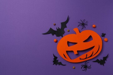 Various decorations and colorful Halloween pumpkin  on violet-themed area
