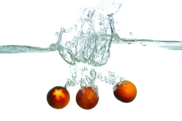 Fresh Red Tomatoes Splashing Into Water With Bubbles And Ripples