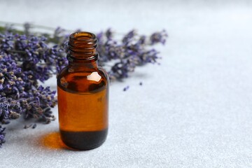 Aromatherapy concept. Lavender oil with flowers on gray background