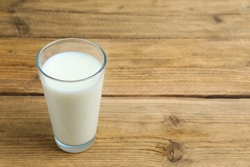 Glass of milk on wooden table