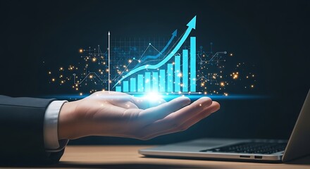 Hand holding digital graph with rising arrow representing business growth financial success and positive market trends in a modern technology driven environment with laptop in
