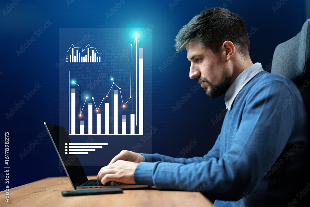 Poster professional man analyzes data on laptop in modern workspace with digital graphs during evening
