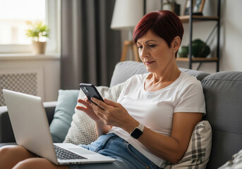  Mature Woman Multitasking with Smartphone and Laptop on Sofa