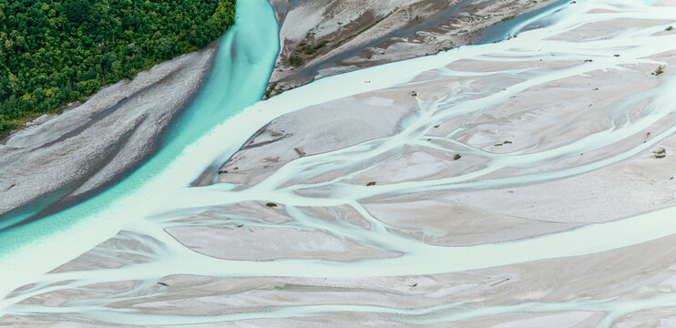 Iconic Italian river Tagliamento, Friuli, Carnia, Italy. Aerial view shows braided river channels and gravel banks, with a forest on the left side.