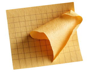 A slightly crumpled, light yellow sticky note on a gridded paper