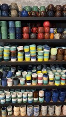 Shelves filled with an assortment of vibrant, handcrafted ceramic mugs