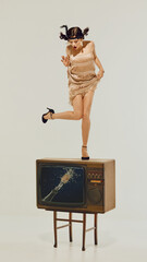 Woman in flapper dress standing shocked on retro TV with exploding champagne image on screen....