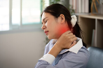 Office Syndrome: Woman at desk rubbing neck to relieve discomfort