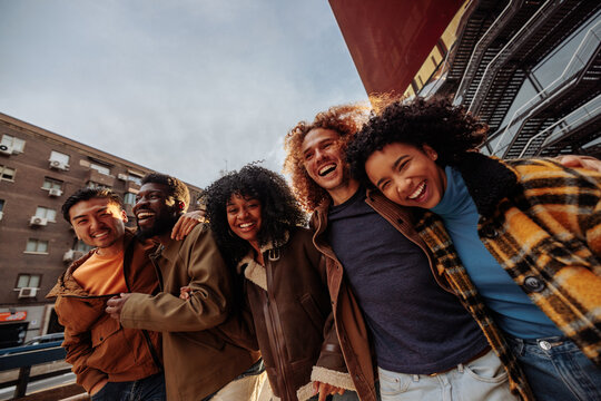 Happy multiracial friends laughing and walking in the city - Powered by Adobe