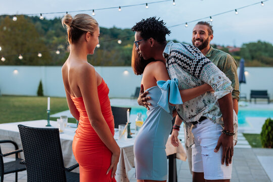 Friends hugging at a pool party enjoying summer holidays - Powered by Adobe