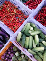 Various kinds of colorful fresh vegetables in plastic boxes sell at traditional market.