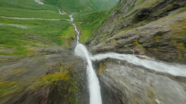 Aerial view of the cascading Mardalsfossen waterfall, plummeting down steep rocky cliffs amidst lush green vegetation, Eikesdal, More og Romsdal, Norway.
