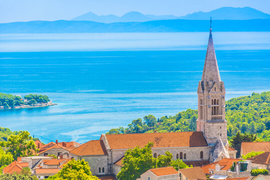 Fototapeta View of the charming village of Selca on Brac island featuring stone buildings, church tower, narrow streets and Mediterranean greenery under the bright Adriatic summer sky