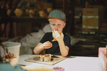 Boy focused on clay modeling in warmly lit studio