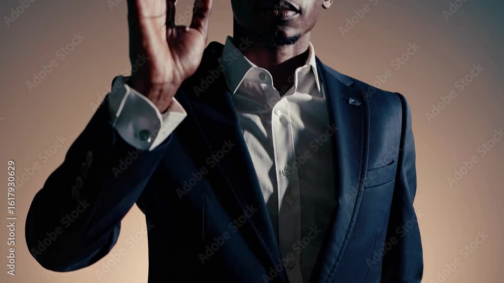 Poster moody video portrait of a man in a suit, captured from a low angle with dramatic lighting, creating 