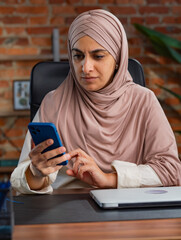 Focused Professional Woman Using Smartphone in Modern Office Space