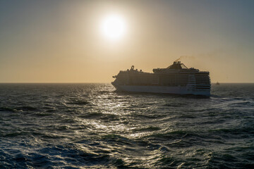 Luxury cruise ship goes into horizon at sunset
