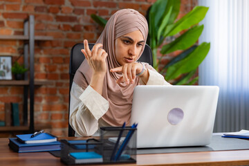 Focused Woman in Hijab Using Smartwatch in Modern Office Setting