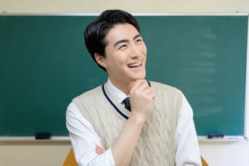 黒板の前で考える日本人男性