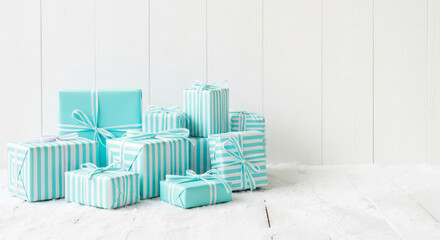 turquoise striped christmas gift boxes on white wooden background

