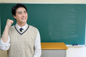 黒板の前に立つ日本人男性