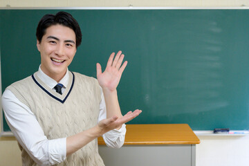 黒板の前で案内をする日本人男性