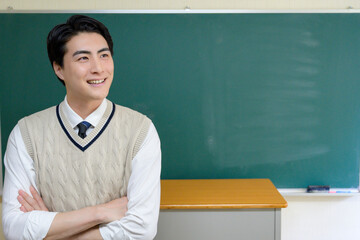黒板の前に立つ日本人男性