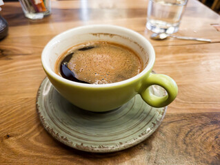 Green Coffee Cup on Wooden Cafe Table