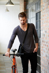 Creative, man and walking with bicycle in hallway for sustainable travel, eco friendly and transport. Confident, male person and pride with bike for commute, carbon footprint and environment wellness