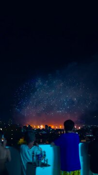 Silhouette of people watching fireworks at night celebration, crowd enjoying festive fireworks display, excitement and holiday spirit 4k