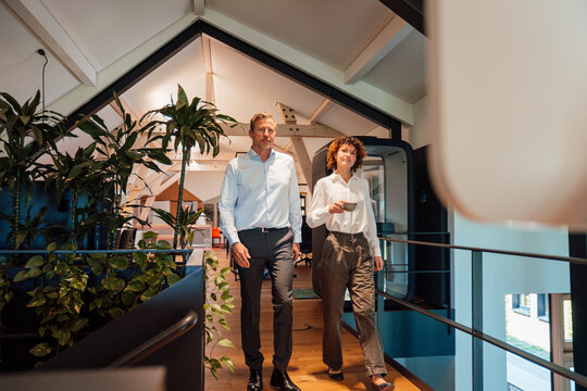 Business professionals walking and conversing inside modern office
