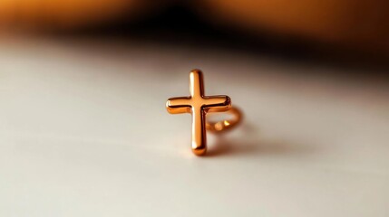 Obraz premium Elegant gold cross ring resting on a textured surface in soft lighting