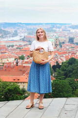 Young female traveler admiring panoramic city view in summer outfit.