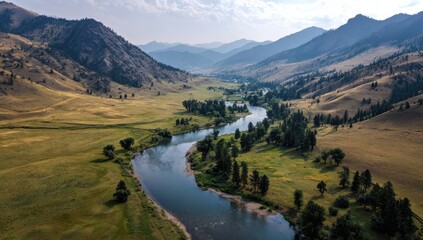 Obraz premium Scenic river winding through a valley surrounded by mountains