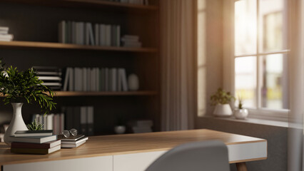 Glasses on books and flower vase on wooden table in room with bookshelf and sunlight through window.