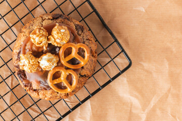 Fresh chocolate American chip cookie decorated with salted camel and caramel popcorn on cooling...