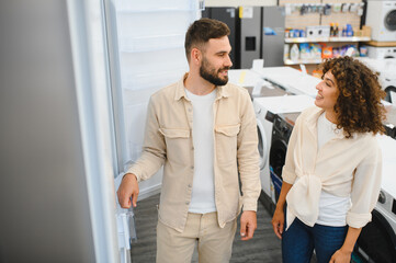 Couple choosing refrigerator in electronics store