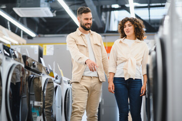 Couple choosing washing machine in electronics store