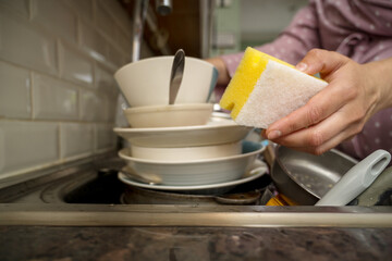 Female hands washing dishes in kitchen, clean space - clean mind