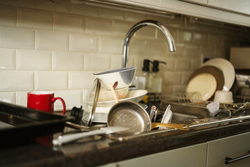 Dirty dishes in kitchen's sink, daily chores, cleaning home 