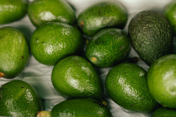 Fresh avocado at small local urban market. Organic produce on sale at outdoor farmer market. Selling fresh crops and veggies harvest. European urban setting. Close up. Part of the series