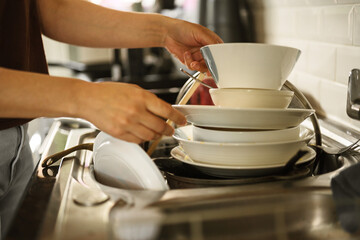 Female hands washing dishes in kitchen, clean space - clean mind