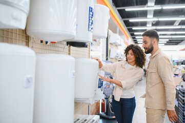 Couple choosing water heater in electronics store