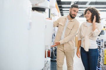 Couple choosing water heater in electronics store